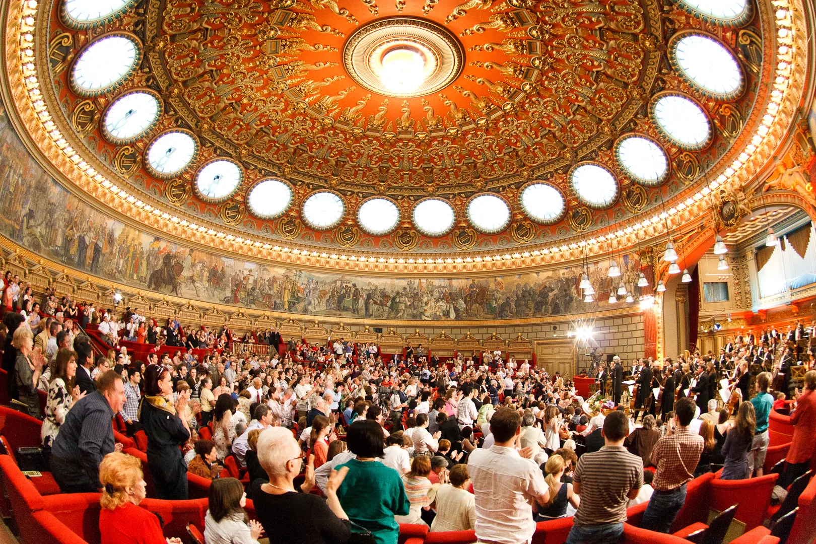 The circular auditorium of the Romanian Athenaeum in Bucharest, ringed by its gold-leaf and the great history fresco beneath the dome