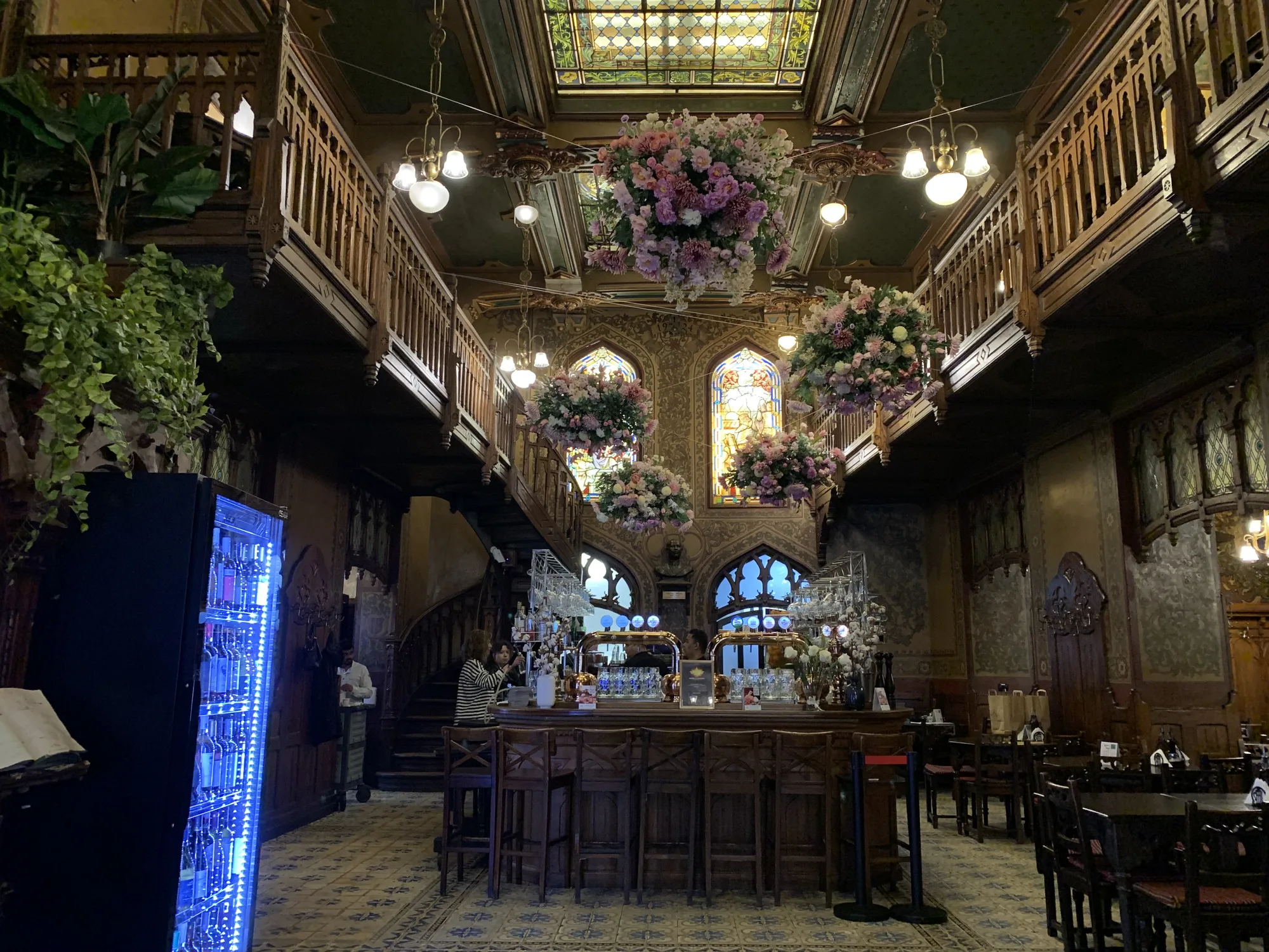 The neo-Gothic interior of the Caru' cu Bere beer hall in Bucharest, with carved dark-wood balconies, stained glass and a painted ceiling