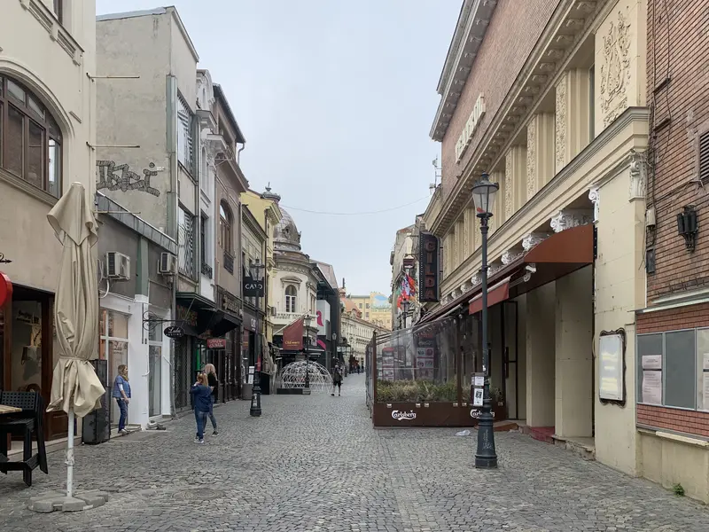 Cobbled Strada Lipscani in Bucharest's Old Town, lined with Belle-Époque townhouses and café terraces