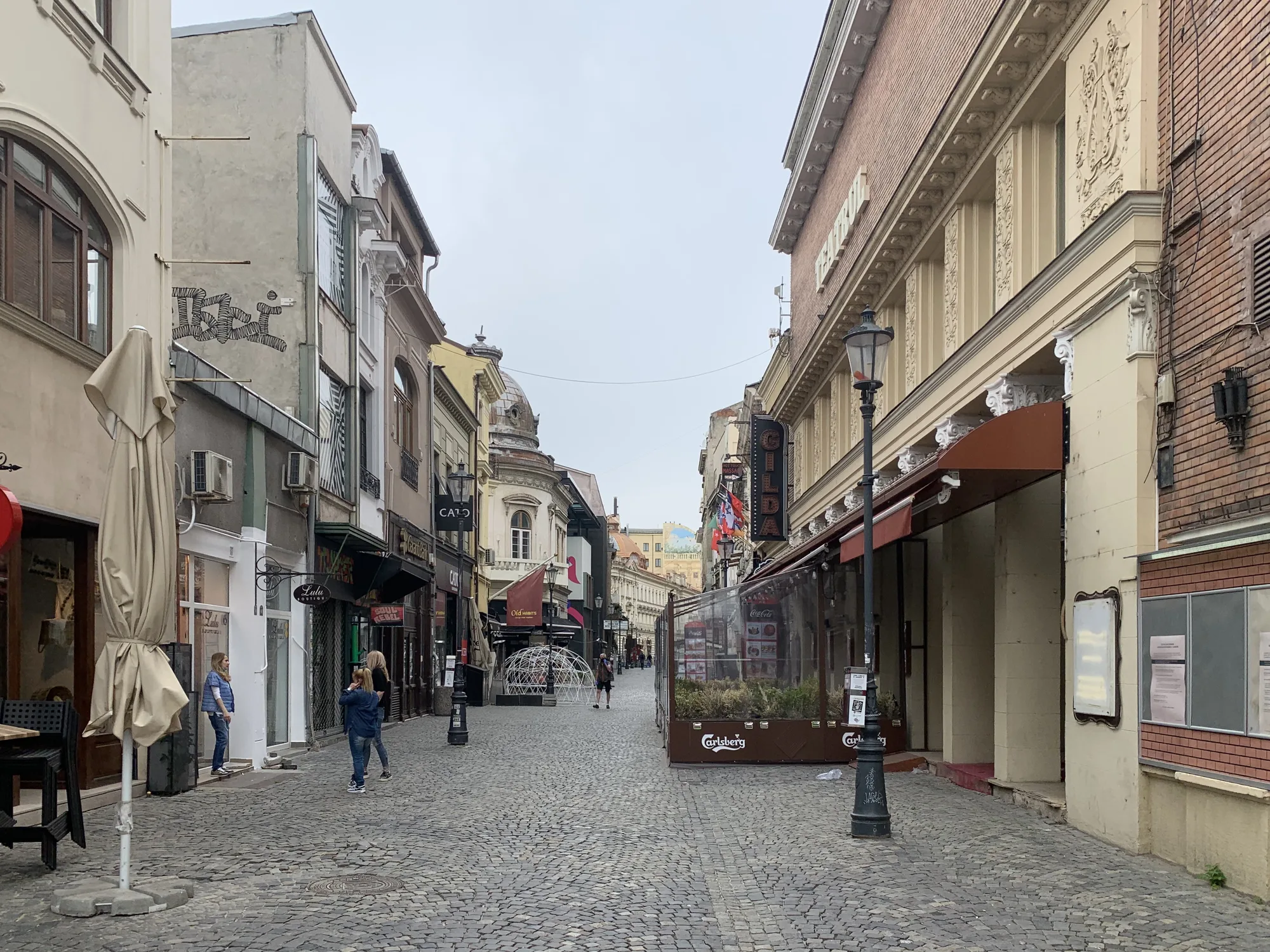 Cobbled Strada Lipscani in Bucharest's Old Town, lined with Belle-Époque townhouses and café terraces