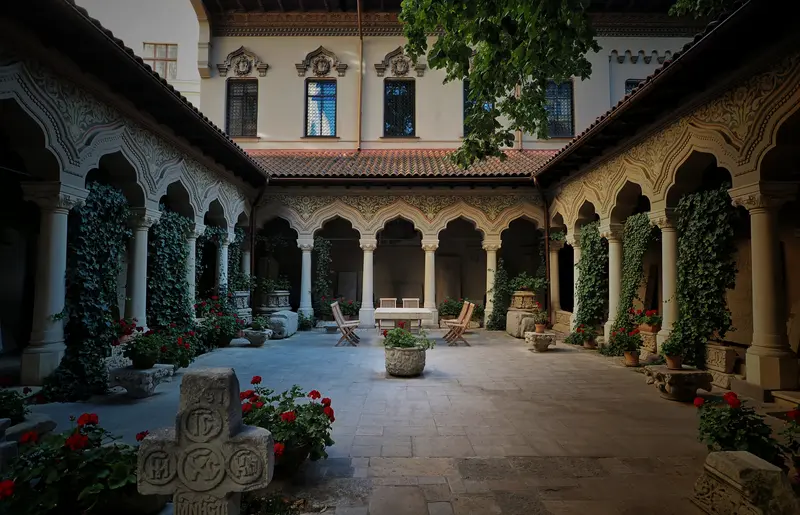The arcaded inner courtyard of Stavropoleos Monastery in Bucharest, with carved stone columns and ivy